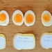 Eggs cut in half and lined up on a cutting board.
